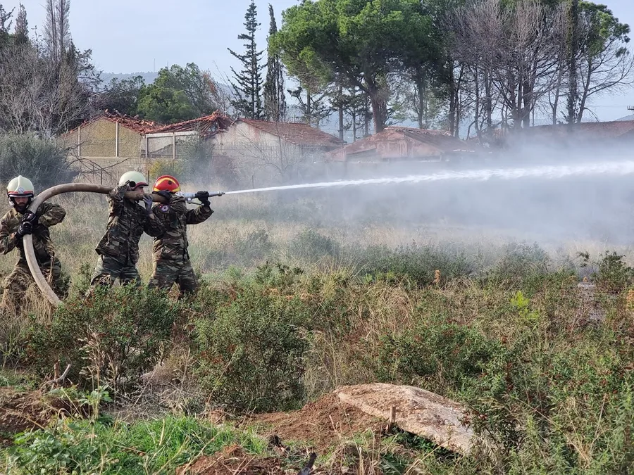 Πυροσβέστες ρίχνουν νερό σε δασική πυρκαγιά στην Ελλάδα